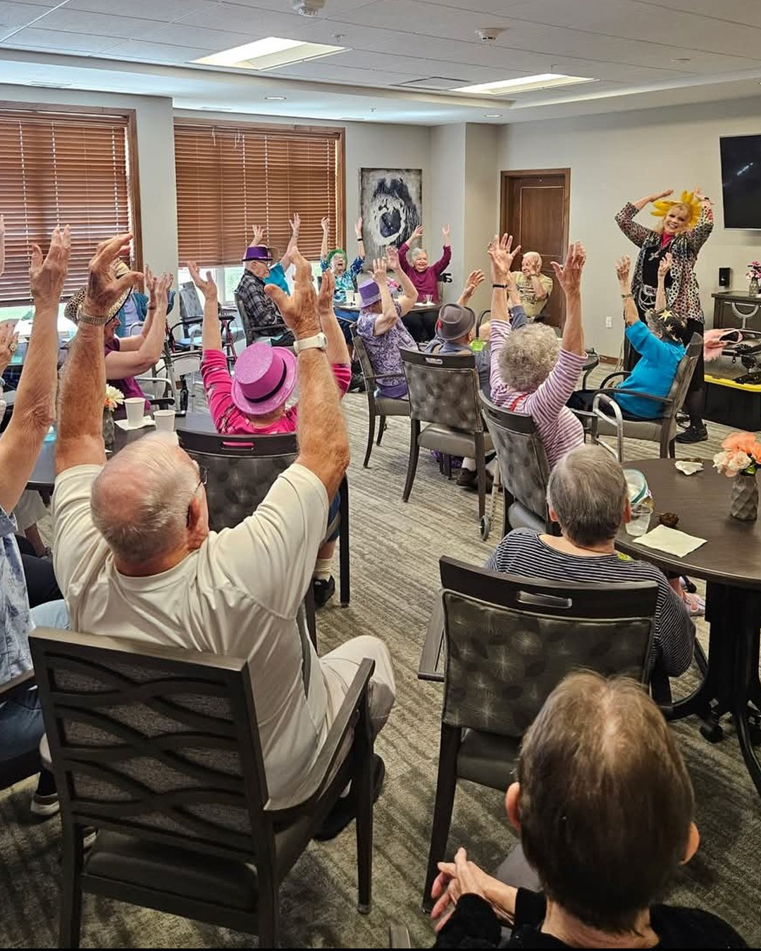Residents raise their hands in a lively group activity at Stoney Point Meadows