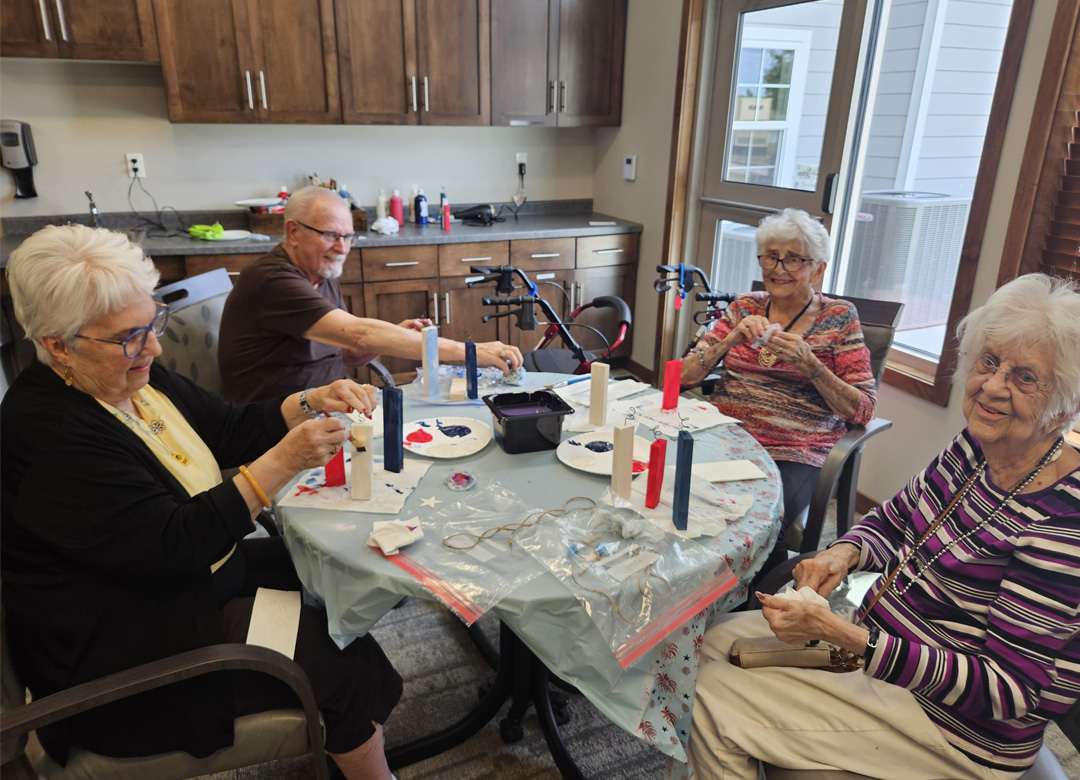 Residents engage in a creative painting project at a communal table