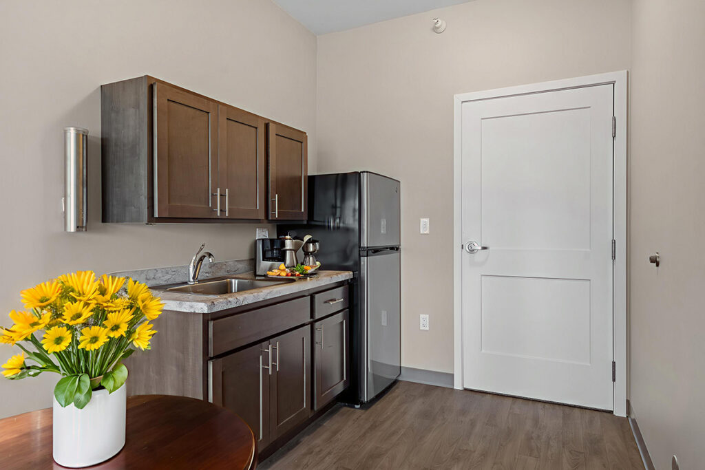 Apartment kitchenette with wood cabinets, sink, countertop appliances, and a compact refrigerator in a private living space at Stoney Point Meadows