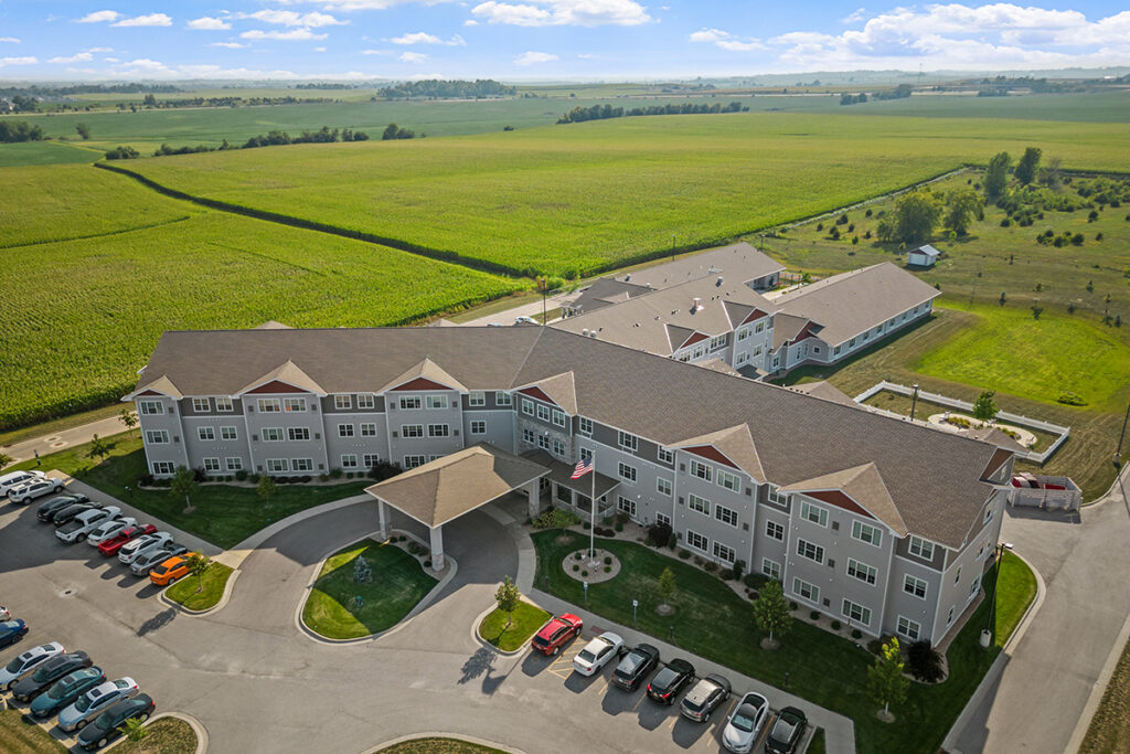 Aerial view of Stoney Point Meadows showing the main building, covered entrance, parking area, landscaped grounds, and surrounding farmland