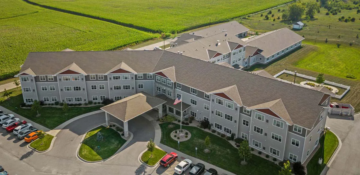 Aerial view of Stoney Point Meadows showing the main building entrance, covered drop-off, parking area, and surrounding farmland landscape