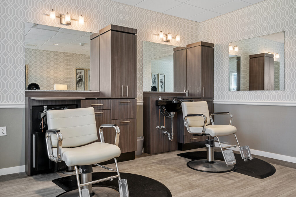 Salon room with styling chairs, wash stations, mirrors, cabinetry, and decorative lighting at Stoney Point Meadows
