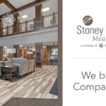 Stoney Point Meadows senior living community lobby with a stone fireplace, wood accents, comfortable seating, and the message: “We bring Compassion.”